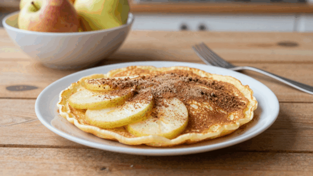 Apfelpfannkuchen mit Zimtzucker auf einem weißen Teller