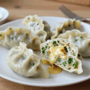 Semmelknödel aus alten Brötchen auf einem weißen Teller mit brauner Butter