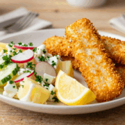Knusprige Fischstäbchen aus dem Ofen mit Kartoffelsalat und Zitronenspalte