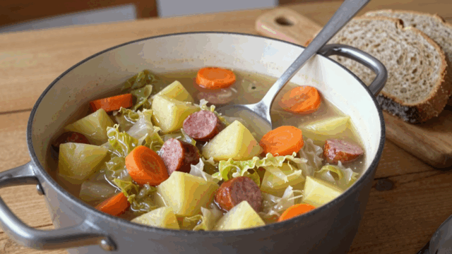 Wirsingeintopf mit Kartoffeln, Möhren und Mettwurst im großen Topf